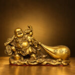 Front studio view of the gold-finished copper Laughing Buddha with money bag