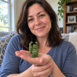 Woman in her thirties holding the 6.5 cm green resin Laughing Buddha on her open palm at home