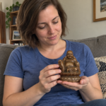 Woman holding the 11 cm copper Laughing Buddha statue in a home