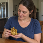 Woman holding the 5 cm resin Laughing Buddha statue in a home