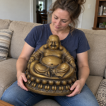 Woman holding the 42 cm antique-gold brass Laughing Buddha on her lap in a living room