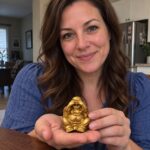 Gold Laughing Buddha Statue held by a woman at home