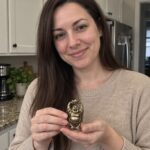 Standing Laughing Buddha Statue with Ingot held by a woman at home