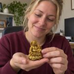Gold Laughing Buddha Statue with Money Bag and Coins held by a woman at home