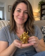 Woman casually holding the small gold Laughing Buddha statue in her hands at home