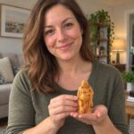 Woman holding the small 12 cm cypress wood Laughing Buddha statue at home
