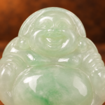 Close-up detail of the same front carving on the pale green jadeite Laughing Buddha pendant