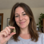 Woman holding a 3 cm brass Laughing Buddha in natural home light