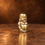 Source-supported three-quarter side studio view of the miniature brass Laughing Buddha