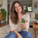 Woman holding a small green Laughing Buddha pendant in her palm