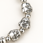 Same-front close detail of smiling Budai face beads and round spacers