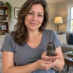 Woman casually holding a miniature resin Laughing Buddha in a cupped palm at home